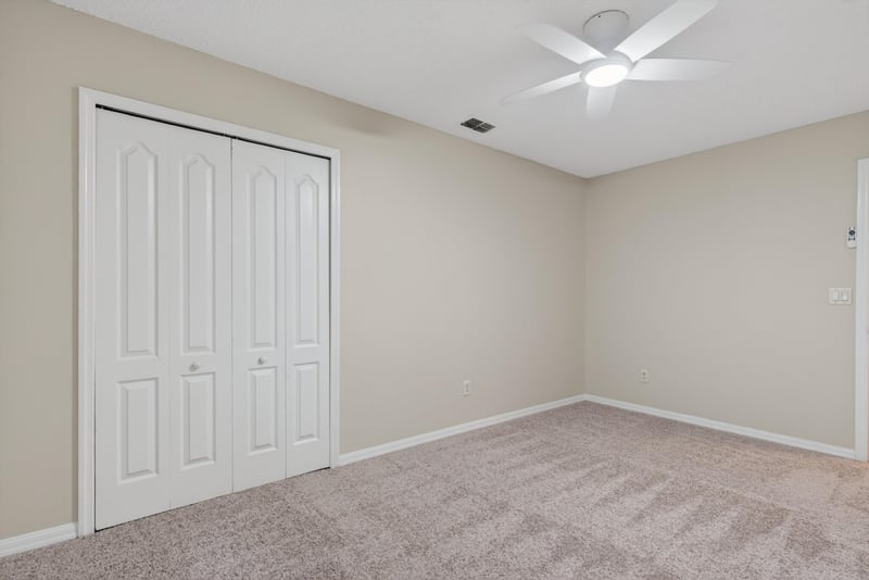 Bedroom with carpet and closet doors at 1648 Glen Laurel Dr, Middleburg, FL 32068