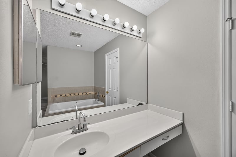 Primary bath vanity and mirror at 1845 Saga Ct, Middleburg, FL
