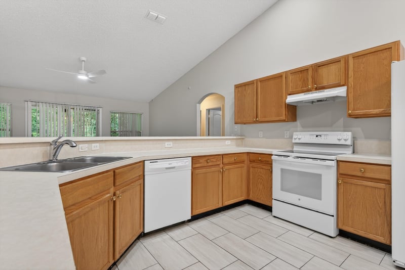 Kitchen with white appliances and vaulted ceiling at 1648 Glen Laurel Dr, Middleburg, FL 32068
