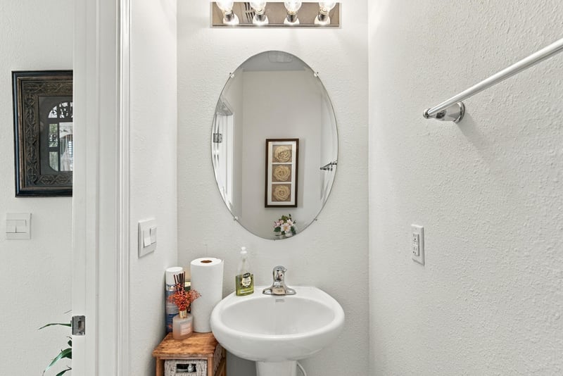 Half bath with oval mirror and pedestal sink at 8359 Zenith Cir, Jacksonville, FL 32256