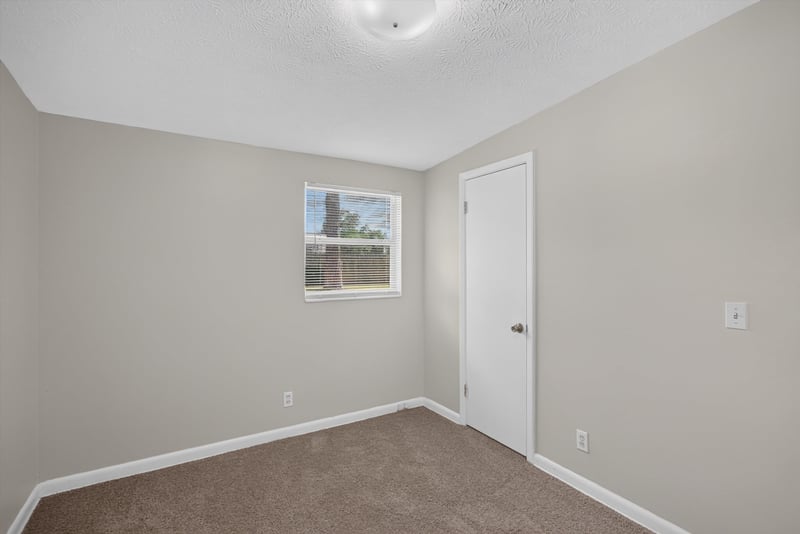 Carpeted bedroom with window at 87 Saratoga Cir S, Atlantic Beach, FL