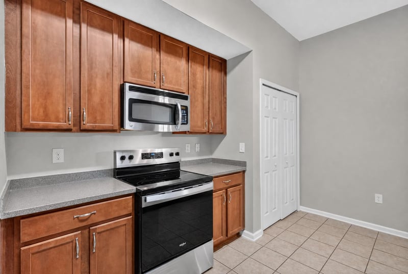 Kitchen cabinets with microwave and pantry closet at 8196 Cabin Lake Cir, Jacksonville, FL 32256