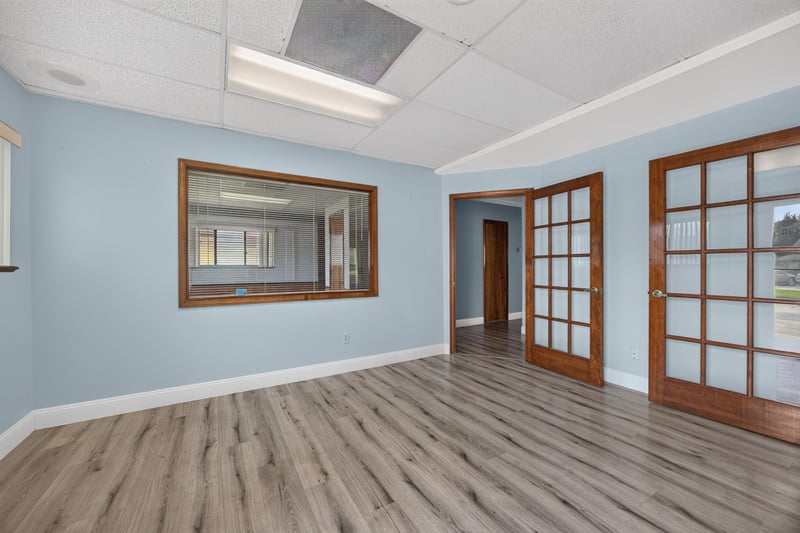 Front room with blue walls, wood-trimmed window and French doors at 1543 Kingsley Ave #19, Orange Park, FL 32073