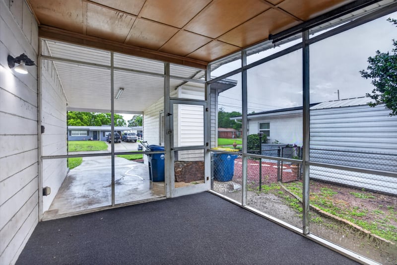 Screened porch with view toward carport at 11462 Elane Dr, Jacksonville, FL