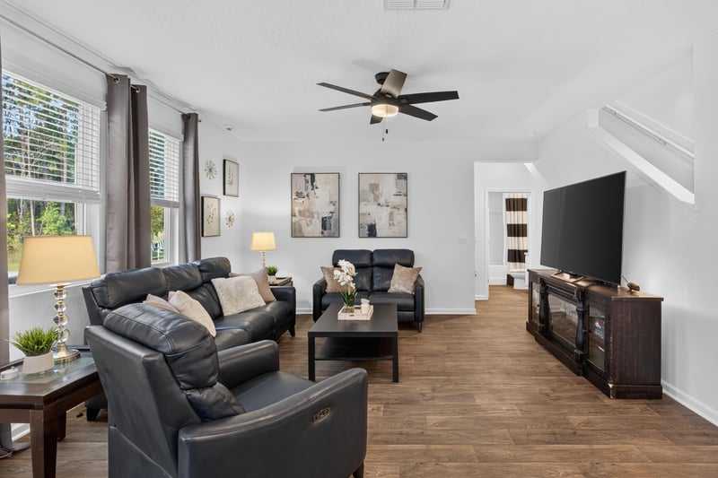 Living room with TV stand and wood-look flooring at 65255 Frst Glen Ln, Yulee, FL 32097