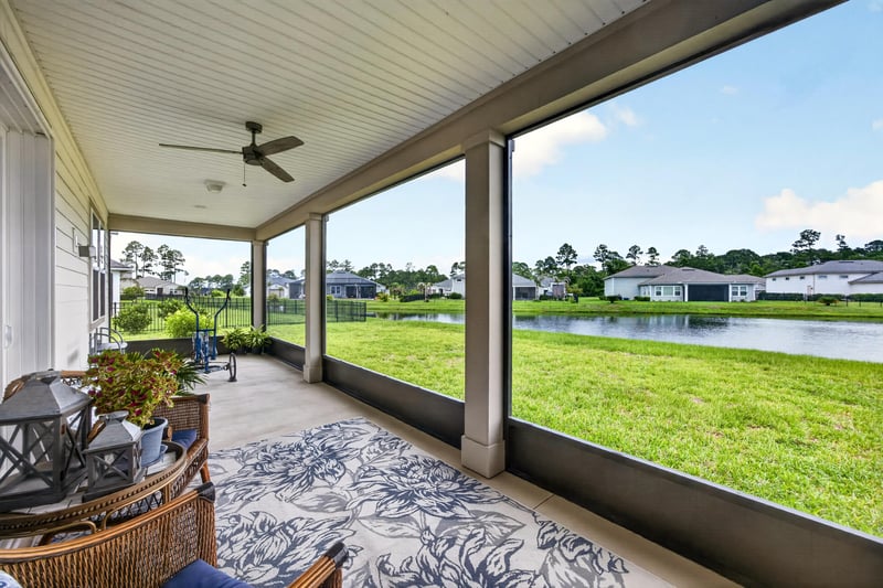 Screened porch with pond view and seating at 85491 Fall River Pkwy, Fernandina Beach, FL 32034