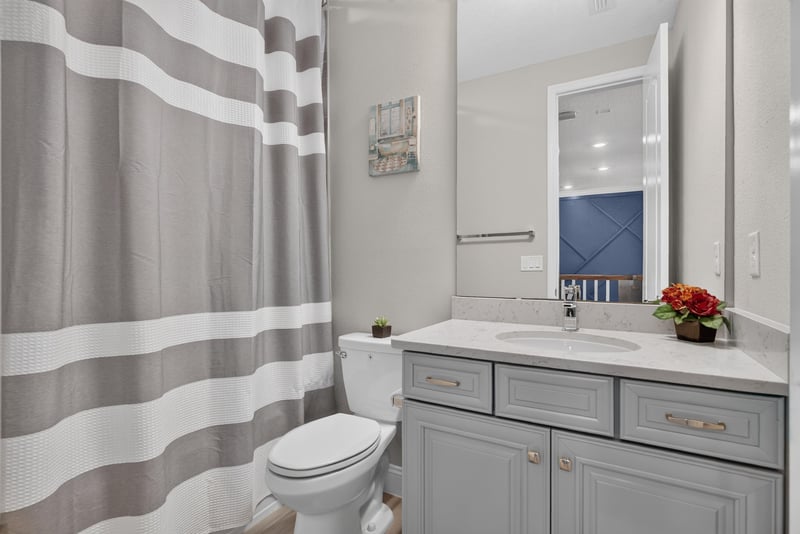Bathroom vanity with striped shower curtain at 22 Azura Point