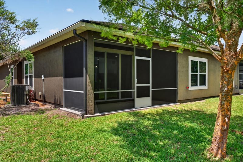 Backyard view with screened porch and AC unit at 2378 Caney Oaks Dr, Jacksonville, FL