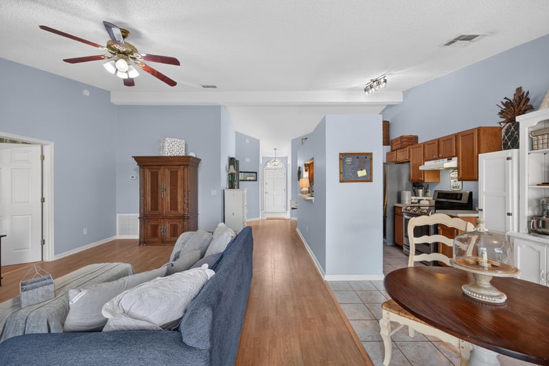 Family room with blue sofa and wood flooring at 4556 Shaky Leaf Ln N, Jacksonville, FL 32224