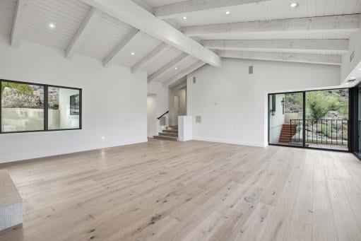 Family room with a beamed ceiling, empty