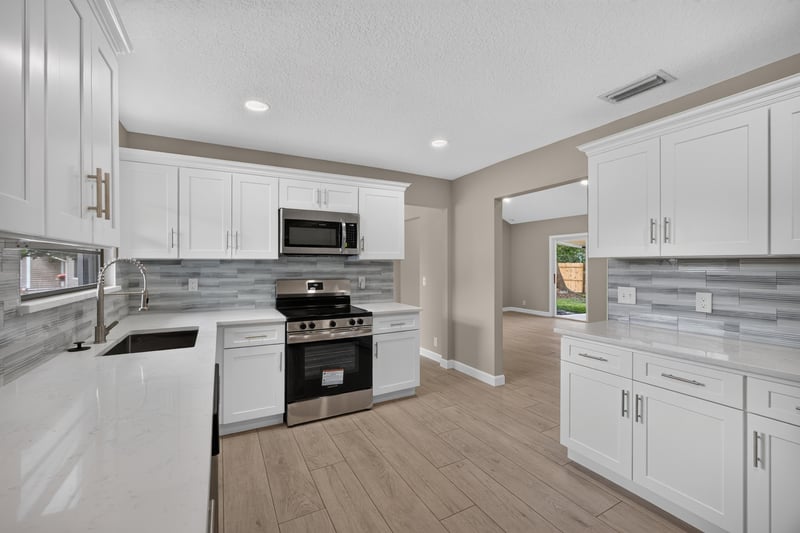 Kitchen range, microwave, and gray tile backsplash at 4117 Wilcrest Ct, Jacksonville, FL 32277