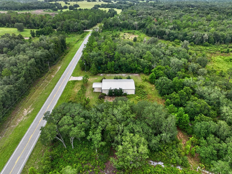 Drone aerial of the building surrounded by trees at 1038 County Rd 315, Melrose