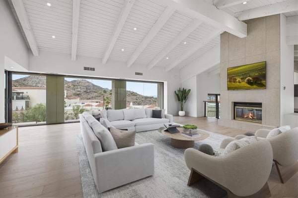 Great room with a beamed ceiling and fireplace, virtually staged