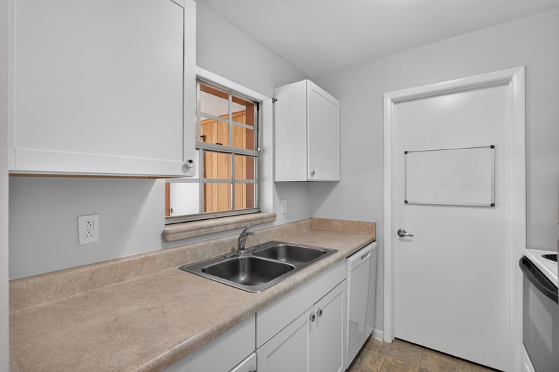 Kitchen counter and white cabinetry with window at 328 Palos Ct, St. Augustine, FL