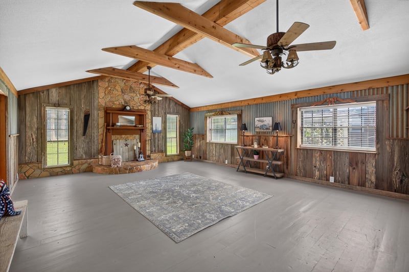 Great room with vaulted wood-beam ceiling and corrugated metal accent wall at 5843 Ovella Rd, Jacksonville, FL 32244