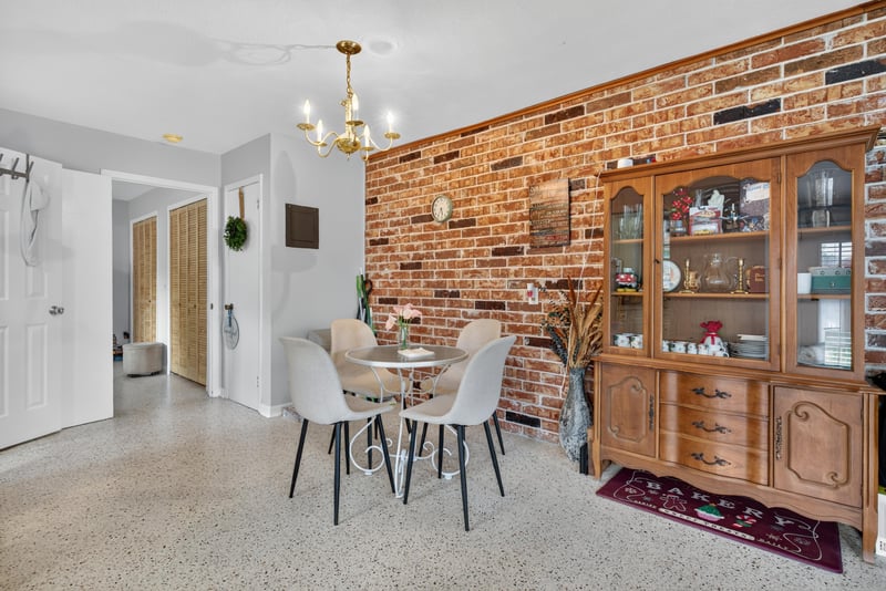 Dining area with brick accent wall and hutch at 5745 110th St, Jacksonville, FL 32244