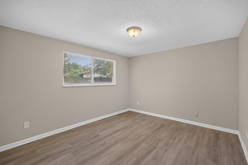 Bedroom with window and wood-look flooring at 1435 Undine Ave, Jacksonville, FL