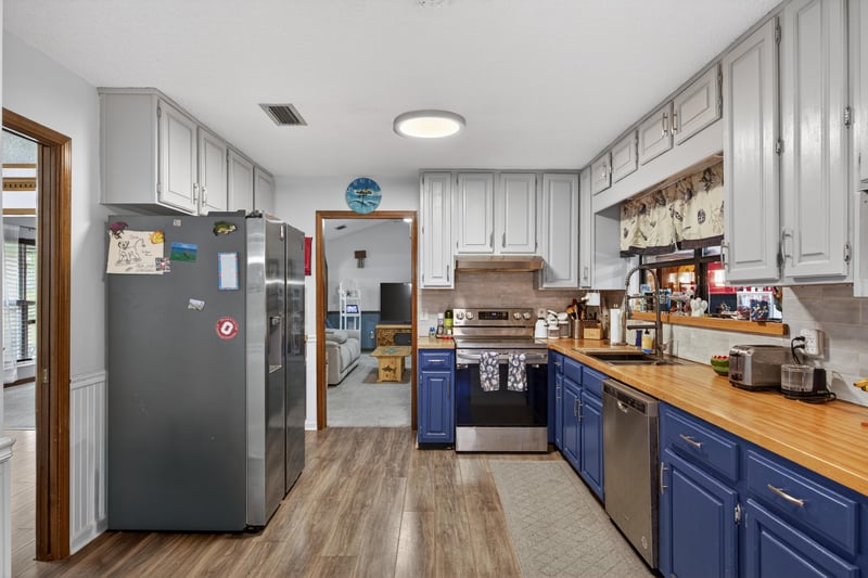 Kitchen with stainless appliances and blue cabinetry at 981 Marble Ridge Dr, Orange Park, FL 32065