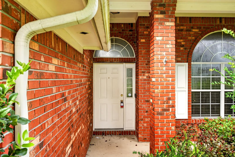 Front entry with brick archway and door at 11669 Collins Creek Dr, Jacksonville, FL 32258