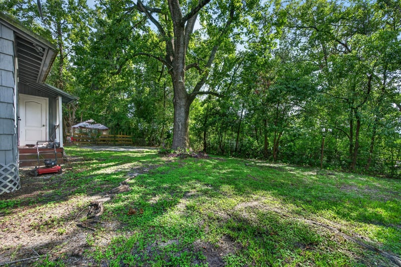 Backyard with mature trees and open lawn at 2132 Allandale Cir W, Jacksonville, FL