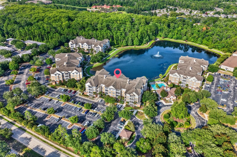 Aerial view of condo buildings, pool, and lake in Jacksonville, FL