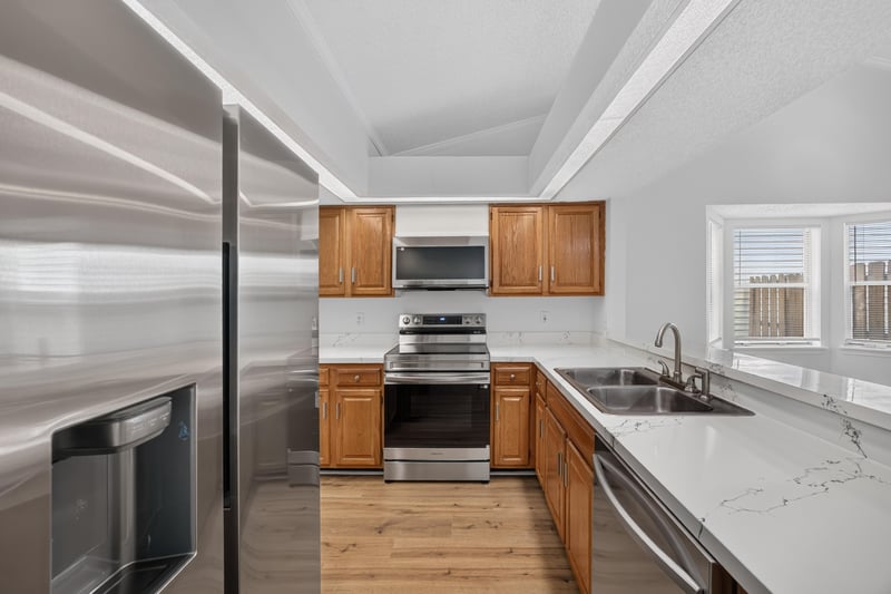 Kitchen view with stainless appliances and tray ceiling at 8047 Mactavish Way E, Jacksonville, FL 32244