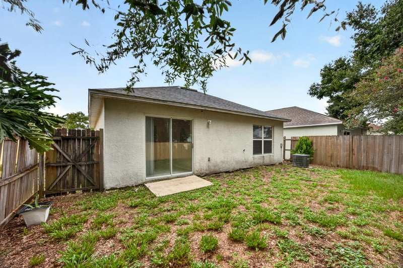 Backyard with grass and patio slab at 7329 Lawn Tennis Ln, Jacksonville, FL