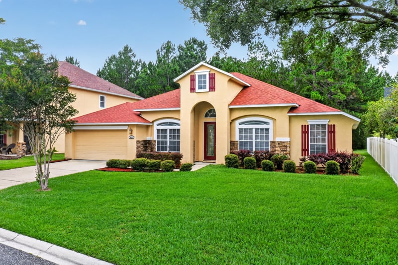 Front exterior with arched entry and landscaping at 635 Wakeview Dr, Orange Park, FL 32065
