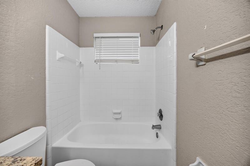 Bathroom with tub-shower combo and window at 2719 Trollie Ln