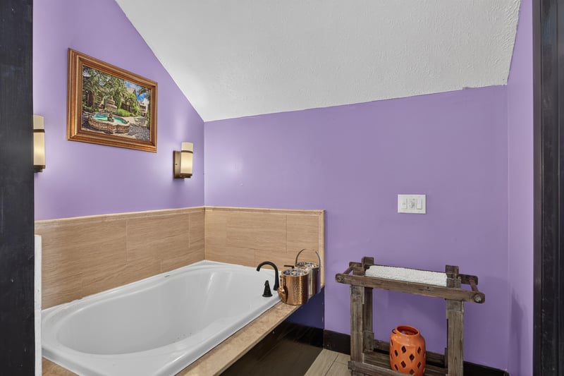 Bathroom with a soaking tub and purple accent wall at 115 Cordova St, St. Augustine, FL