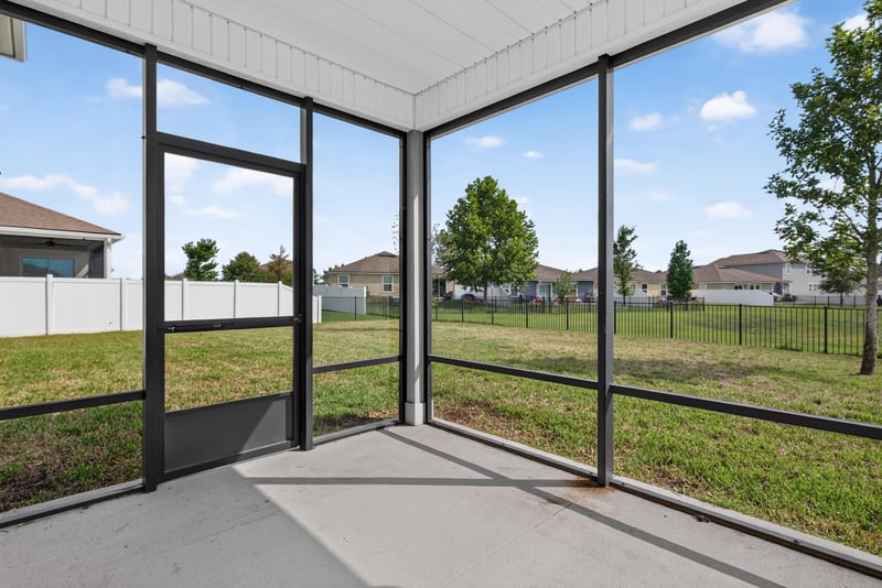Screened lanai with concrete floor and yard view at 2580 Cold Stream Ln, Green Cove Springs, FL 32043