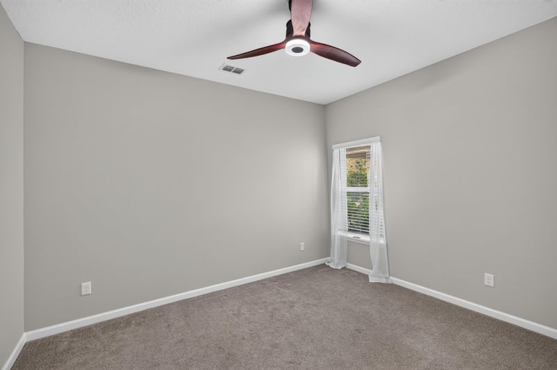 Carpeted bedroom with window and ceiling fan at 75875 Saffron Ln, Yulee, FL 32097