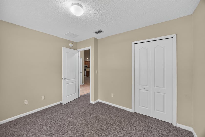 Carpeted bedroom with closet doors at 469 Glendale Ln, Orange Park, FL