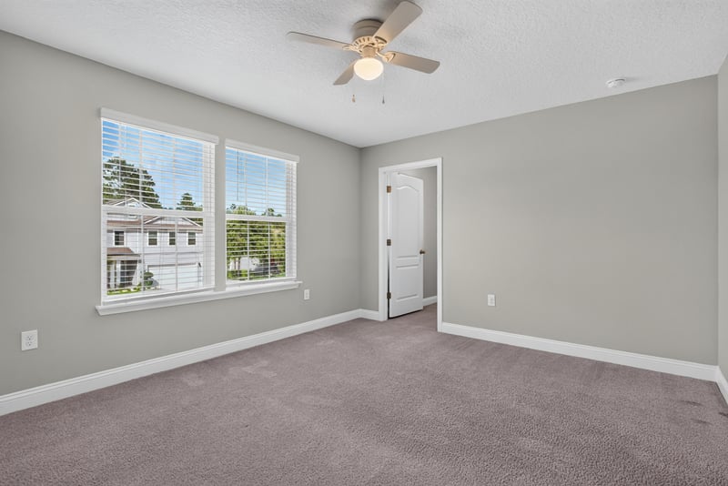 Carpeted bedroom with two windows at 2580 Cold Stream Ln, Green Cove Springs, FL 32043