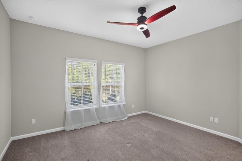 Carpeted bedroom with window and ceiling fan at 75875 Saffron Ln, Yulee, FL 32097