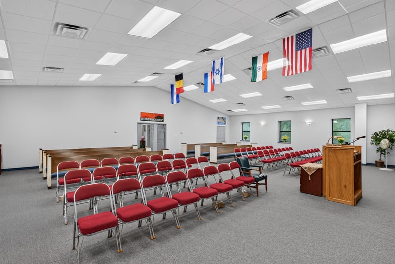 Assembly hall with rows of red chairs and ceiling flags at 1038 County Rd 315, Melrose