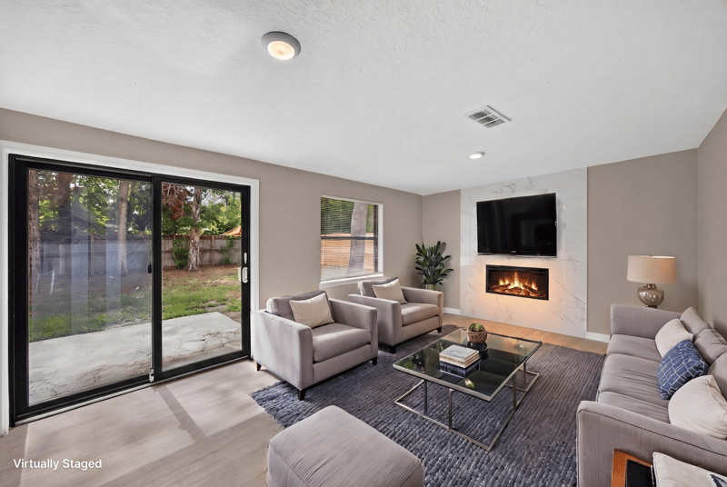 Virtually staged living room with fireplace and sliding glass doors at 184 Draco St, Orange Park, FL 32073