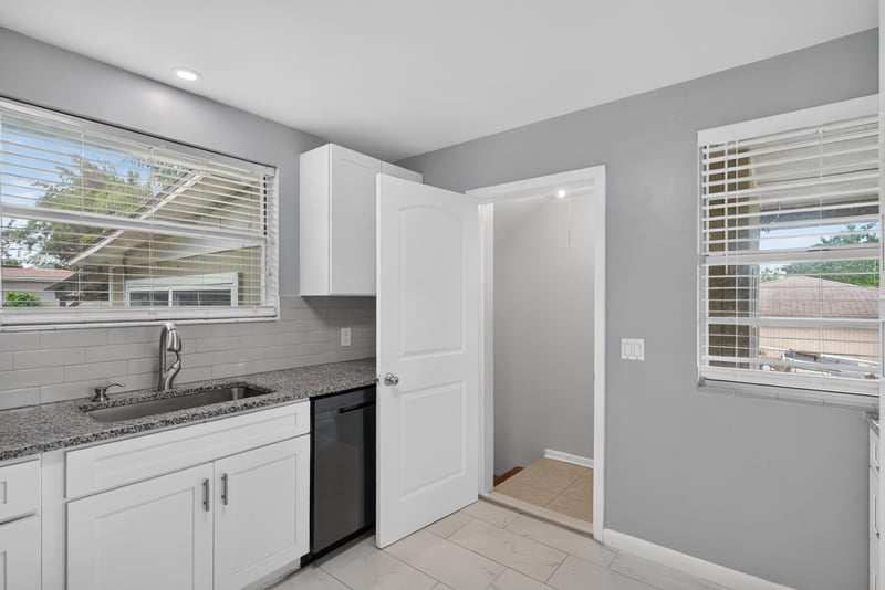 Kitchen with white cabinets, black dishwasher and window at 217 Baisden Rd, Jacksonville, FL 32218