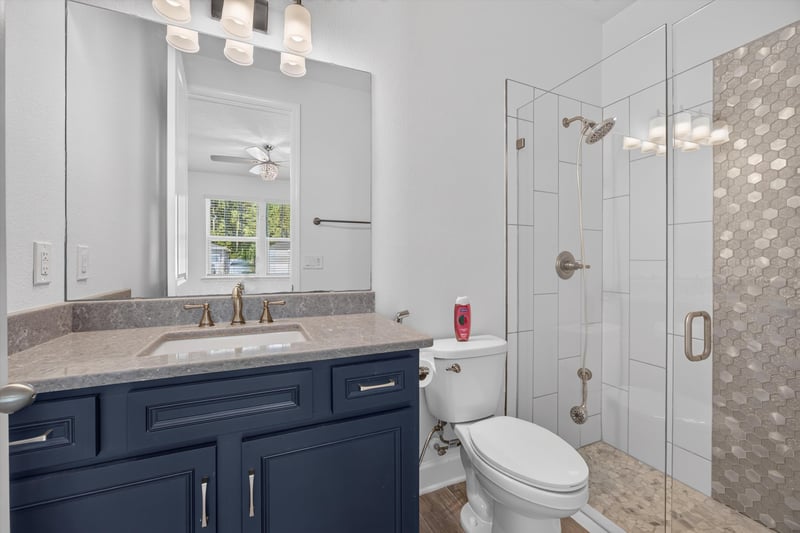 Bathroom with navy vanity and shower at 855 Flach Dr, St. Johns, FL