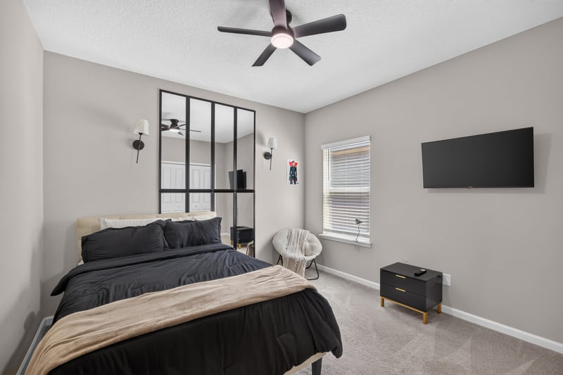 Bedroom with dark accent wall and ceiling fan at 9942 Lovage Ln, Jacksonville, FL 32219