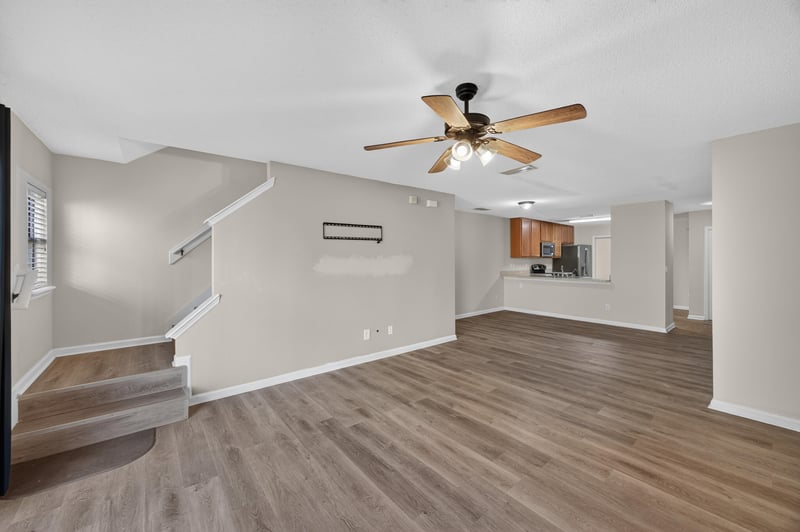 Living area with staircase and kitchen pass-through at 7723 Playschool Ln, Jacksonville, FL