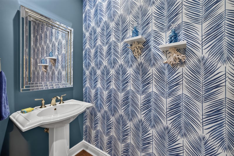 Powder room with pedestal sink and patterned wallpaper at 140 Ave De La Mer, Palm Coast, FL 32137
