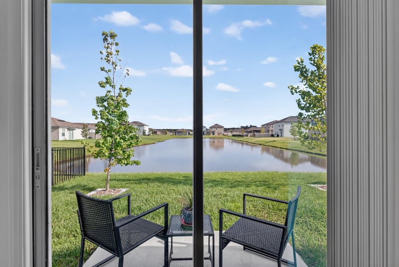 Covered patio with chairs and pond view at 4276 Quaking St, Jacksonville, FL 32218
