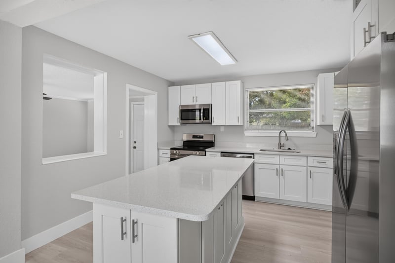 Kitchen island with white cabinetry at 6238 Randia Dr, Jacksonville, FL 32210