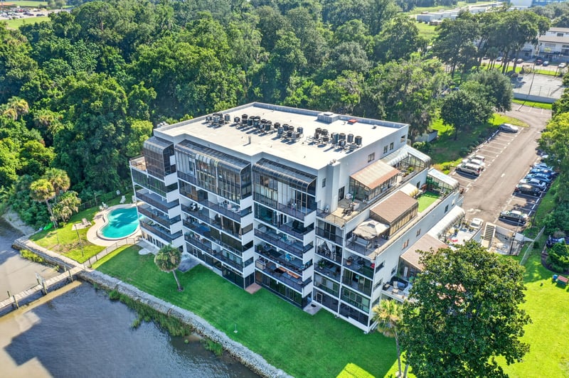 Aerial view of condo building with pool and parking in Jacksonville