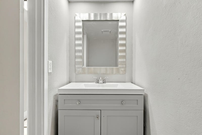 Half bath with vanity and mirror at 7703 Las Palmas Way