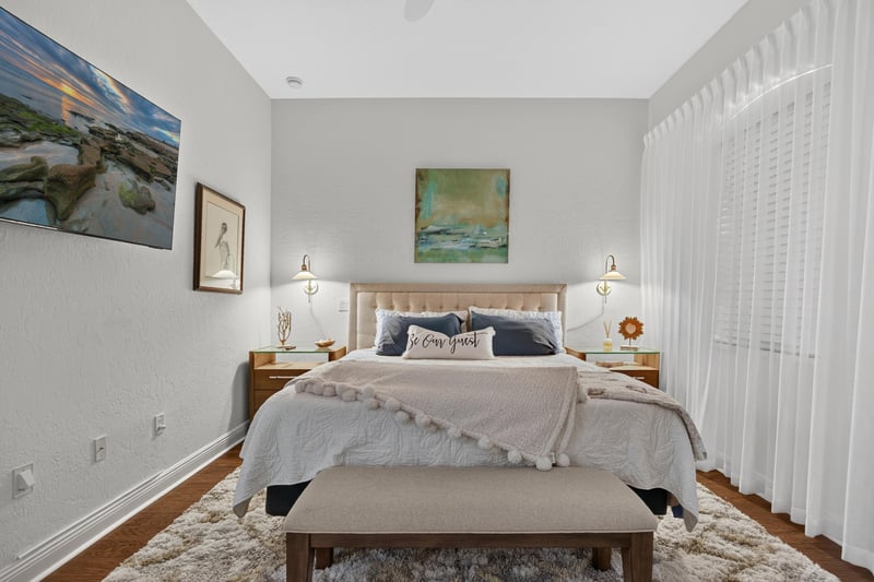 Bedroom with wood nightstands and sheer curtains at 140 Ave De La Mer, Palm Coast, FL 32137