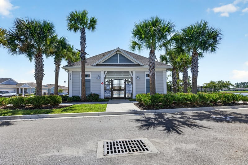 Community clubhouse entrance with palm trees in Highland Chase