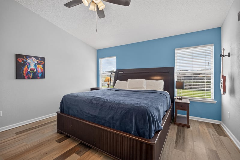 Primary bedroom with dark wood bed and blue accent wall at 2065 Creekmont Dr