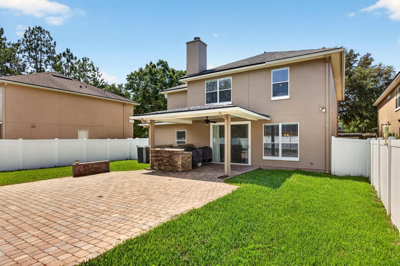 Rear exterior view with covered patio and fenced yard at 3660 Middlebrook Dr, Orange Park, FL 32065